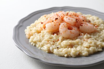 Delicious risotto with shrimps and cheese on white table, closeup