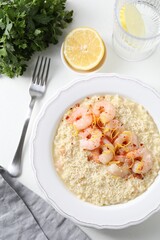 Delicious risotto with shrimps and cheese served on white table, top view