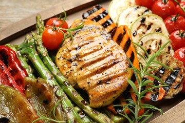Delicious grilled vegetables and chicken breast on table, closeup