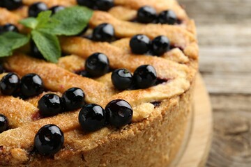 Delicious homemade blueberry pie with mint on table, closeup
