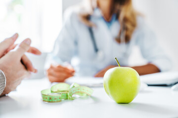 Healthy food concept. Cropped close up of woman doctor dietician recommending senior male patient...