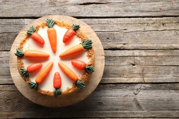 Delicious carrot cake on wooden table, top view. Space for text