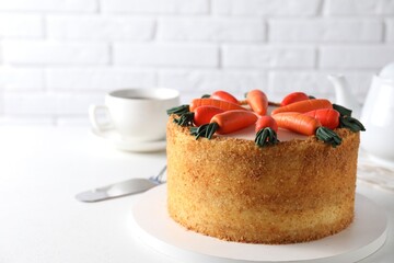 Delicious carrot cake and server on white table, closeup