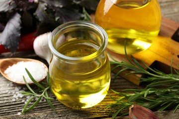 Cooking oil and products on wooden table, closeup