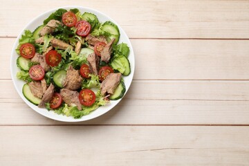 Delicious fresh tuna salad on white wooden table, top view. Space for text