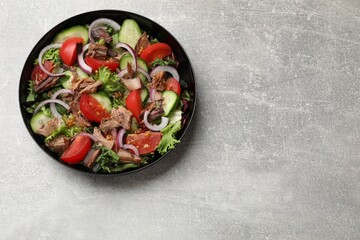 Delicious fresh tuna salad on light grey table, top view. Space for text