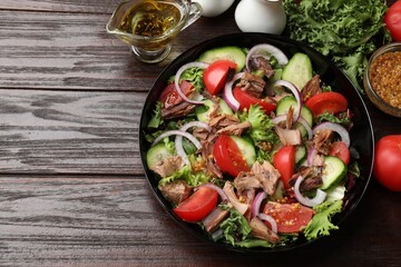 Delicious fresh tuna salad and ingredients on wooden table, top view