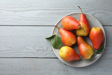 Ripe juicy pears on grey wooden table, top view. Space for text