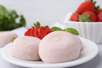 Delicious mochi, strawberries and mint on table, closeup