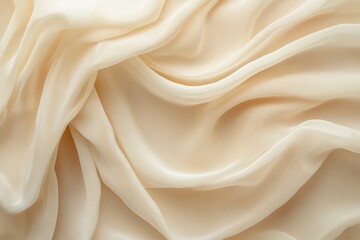 Obraz premium Elegant soft fabric draping in waves, showcasing a creamy beige color and smooth texture.