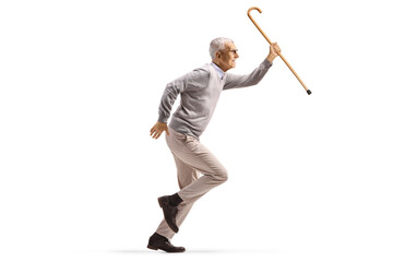 Full length profile shot of a casual elderly man running and holding a cane