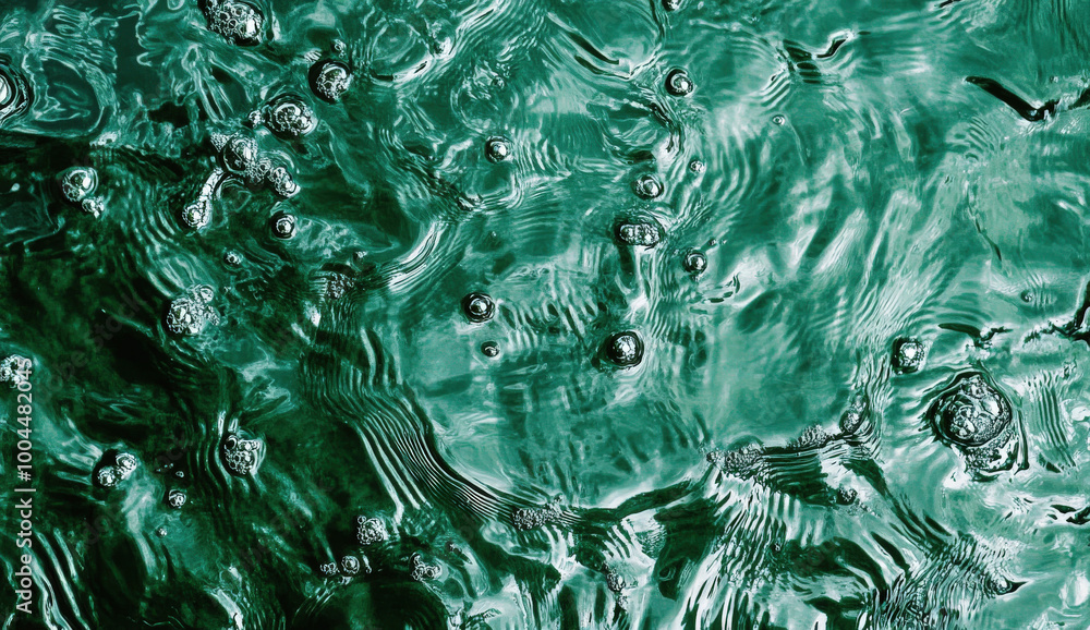 Poster raindrops create mesmerizing patterns on emerald green water in a tranquil natural setting during a 