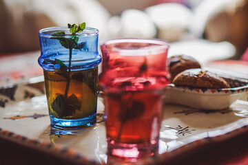 a moroccan plate with  cups of tea with mint and some moroccan traditional cakes