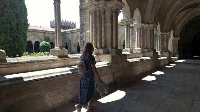 Tourist strolling through the medieval cloister of the cathedral of Tui, Galicia, Spain.
