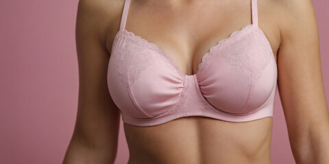 Breast cancer awareness young woman chest in pink bra close-up