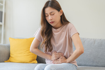 Flatulence asian young woman intolerance hand in stomach ache, suffer from food poisoning,...