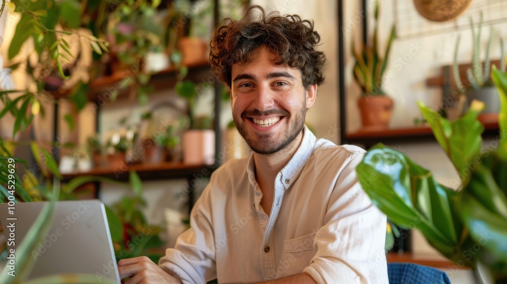 Aufkleber a man is sitting at a table with a laptop and smiling