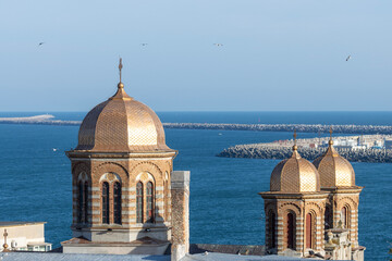The foreground shows the spiers of the cathedral. The domes are decorated with intricate patterns and a cross at the top. The middle path is dominated by the Black Sea, which stretches to the horizon.