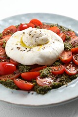 Fresh delicious burrata salad on table, closeup