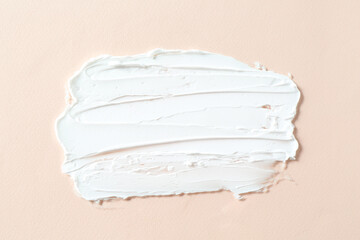 Smear of cosmetic product on beige background, top view