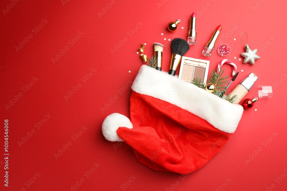 Canvas Prints Santa hat with makeup products and Christmas decor on red background, top view