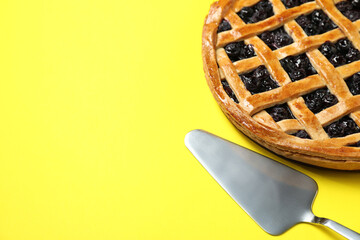 Tasty homemade pie with blueberries and server on yellow table, closeup. Space for text