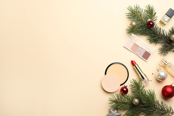 Flat lay composition with makeup products and Christmas decor on beige background. Space for text