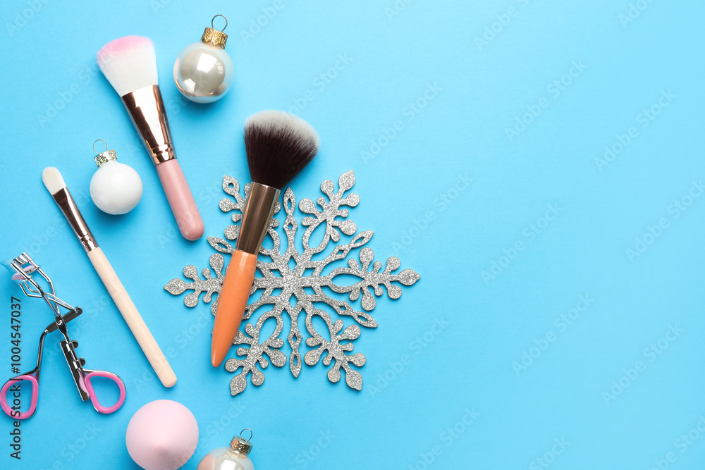 Sticker Makeup brushes, eyelash curler and Christmas decor on light blue background, flat lay. Space for text