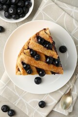 Slice of delicious homemade blueberry pie served on light table, flat lay