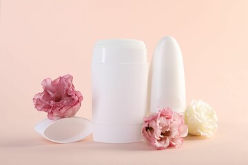 Different deodorants and beautiful eustoma flowers on beige background
