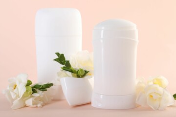 Solid deodorants and beautiful eustoma flowers on beige background