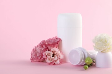 Different deodorants and beautiful eustoma flowers on pink background