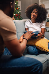 Obraz premium Smiling woman receives a gift from a man on the sofa.