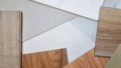 top view of interior material mood and tone board contains wooden vinyl tiles, laminated flooring tile, concrete laminated, ceramic marble tile in close up view. stylish decoration materials.