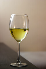 Half full wine glass against neutral background
