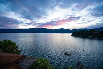 amazing capture of nature landscape with a boat and pink hues in the sunrise sky