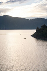 vertical capture of peaceful lake scene with fishermen on small canoes