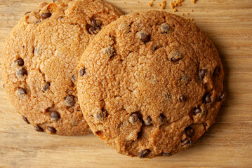 Delicious chocolate chip cookies resting on a rustic wooden background.