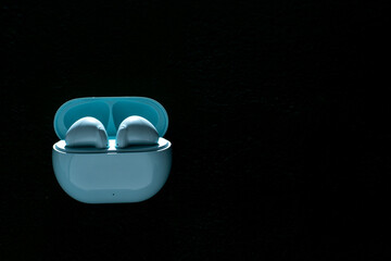 Wireless headphones on black background. Wireless, headphone in charging box