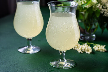 Carbonated elderflower drink. Flower summer kvass in glasses. Sparkling homemade hugo bulbs water.
