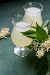 Carbonated elderflower drink. Flower summer kvass in glasses. Sparkling homemade hugo water. Black...