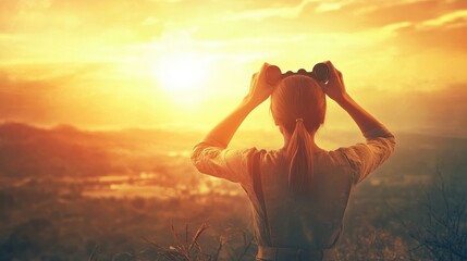 A person looking through binoculars towards the foresight and vision necessary for goal setting