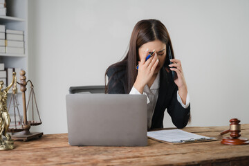The weight of responsibility: A stressed lawyer in a suit wipes a tear from her eye while talking...