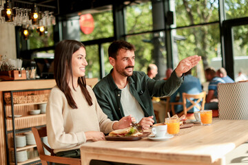Enjoying a delightful brunch together at a cozy cafe on a sunny afternoon in the heart of the city