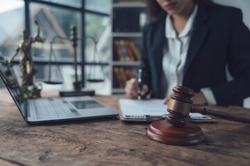 Focused on Justice: A lawyer's hand carefully writes on a notepad, a gavel and scales of justice symbolizing their dedication to the law.