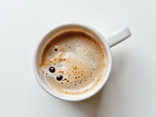 A top view of a coffee cup with a perfectly round foam on a white background
