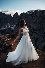 Bride Standing in a Wedding Dress on a Mountain Peak