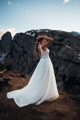 Bride Standing in a Wedding Dress on a Mountain Peak