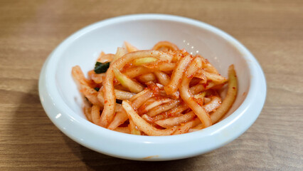 Close-Up of Korean Radish Banchan in a White Bowl on Wooden Table Background