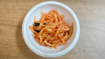 Close-Up of Korean Radish Banchan in a White Bowl on Wooden Table Background